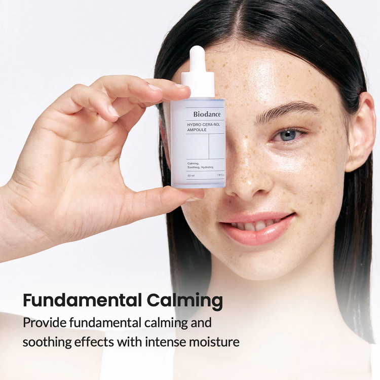 Flatlay of essence bottle with cotton pads and a green tea leaf.