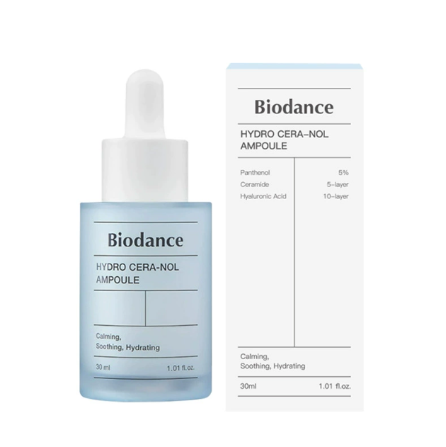 User holding the essence, smiling with radiant complexion after nightly routine.